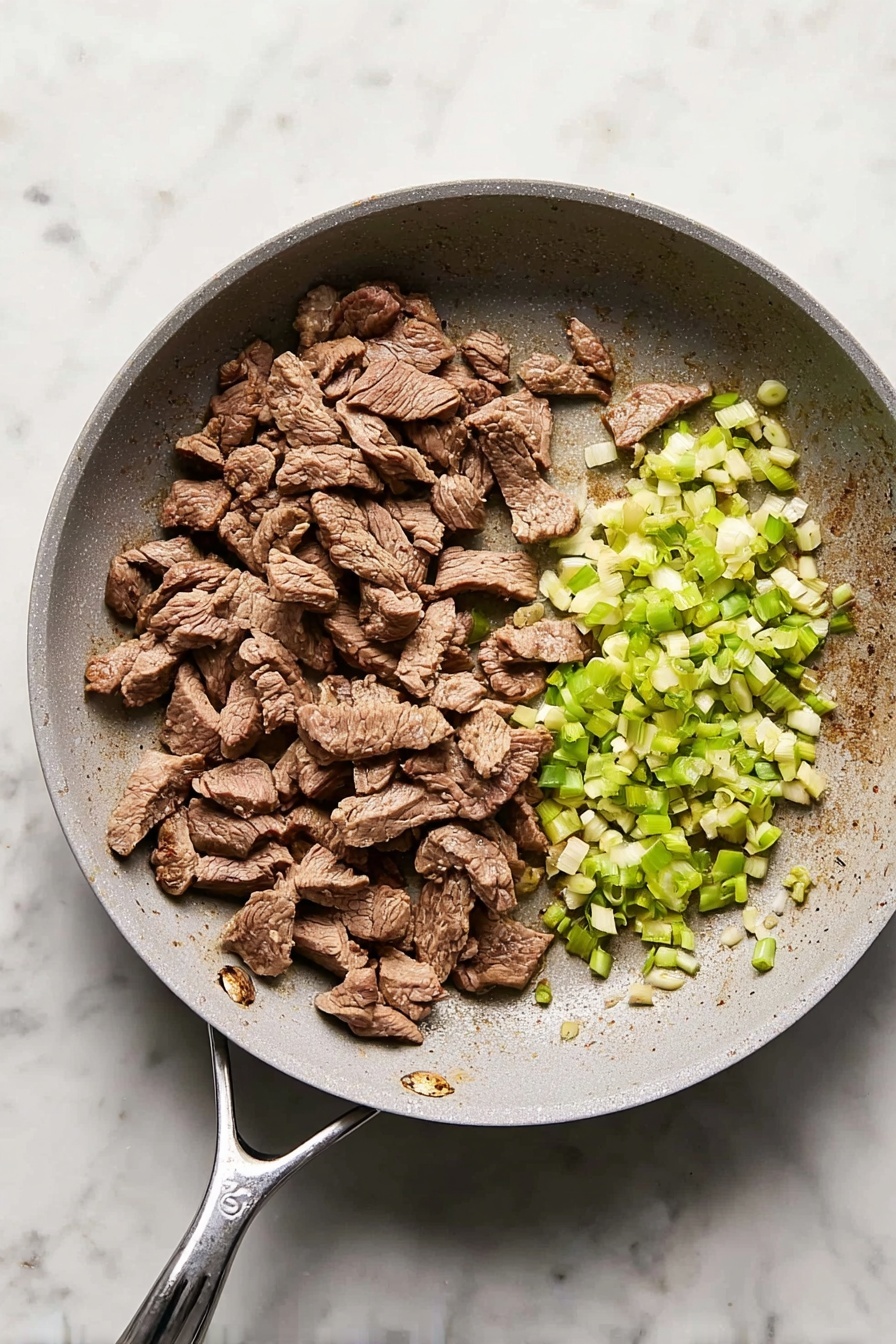 A white frying pan with a grayish interior sits on a white marbled surface. Inside the pan, there are two main layers: on the left side, there are many pieces of cooked meat, brown in color with a slightly rough texture, scattered unevenly. On the right side, there is a small pile of chopped green onions, light green and white, with a smooth fresh look. The pan handle extends to the right side, showing slight discoloration near where it joins the pan. The overall look is simple and clean. photo taken with an iphone --ar 2:3 --v 7