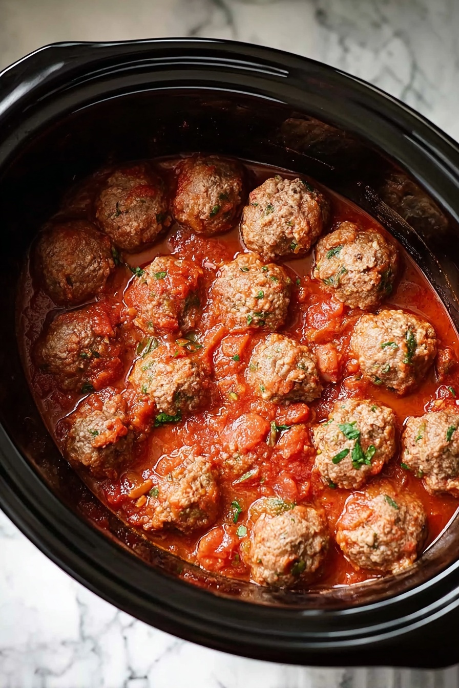 A black slow cooker is filled with about thirty round meatballs that have a light brown color with small green herb bits inside. The meatballs float in a thick, bright red sauce with a slightly chunky texture. The slow cooker is set on a white marbled surface, showing the contrast between the dark cooker and the light background. Photo taken with an iphone --ar 2:3 --v 7