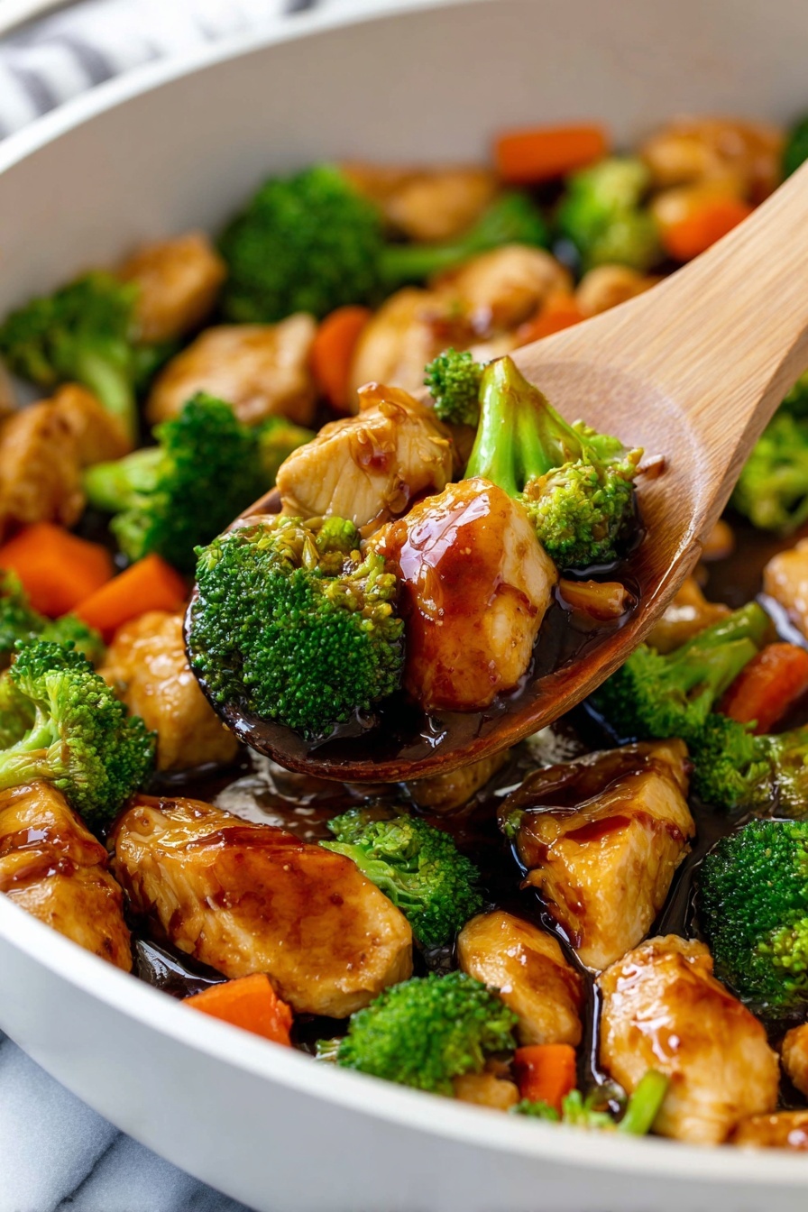 This close-up image shows a white pan filled with a stir-fry dish that has three main layers. The bottom layer is bright green broccoli florets with a slightly bumpy texture. Above that, there are chunks of cooked chicken with a shiny, light brown glaze that looks slightly sticky and smooth. Scattered among the chicken and broccoli are pieces of soft carrot slices, with a bright orange color and smooth surface. A wooden spoon is stirring the mix, lifting some of the ingredients, showing the glossy sauce coating all the pieces. The pan is on a white marbled surface. Photo taken with an iphone --ar 2:3 --v 7